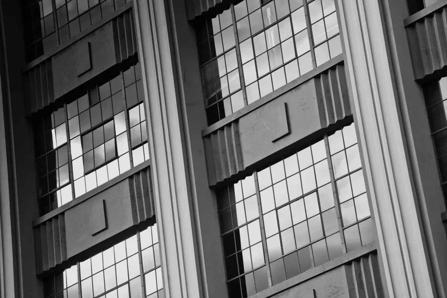 Black and white industrial warehouse facade with tall grid windows